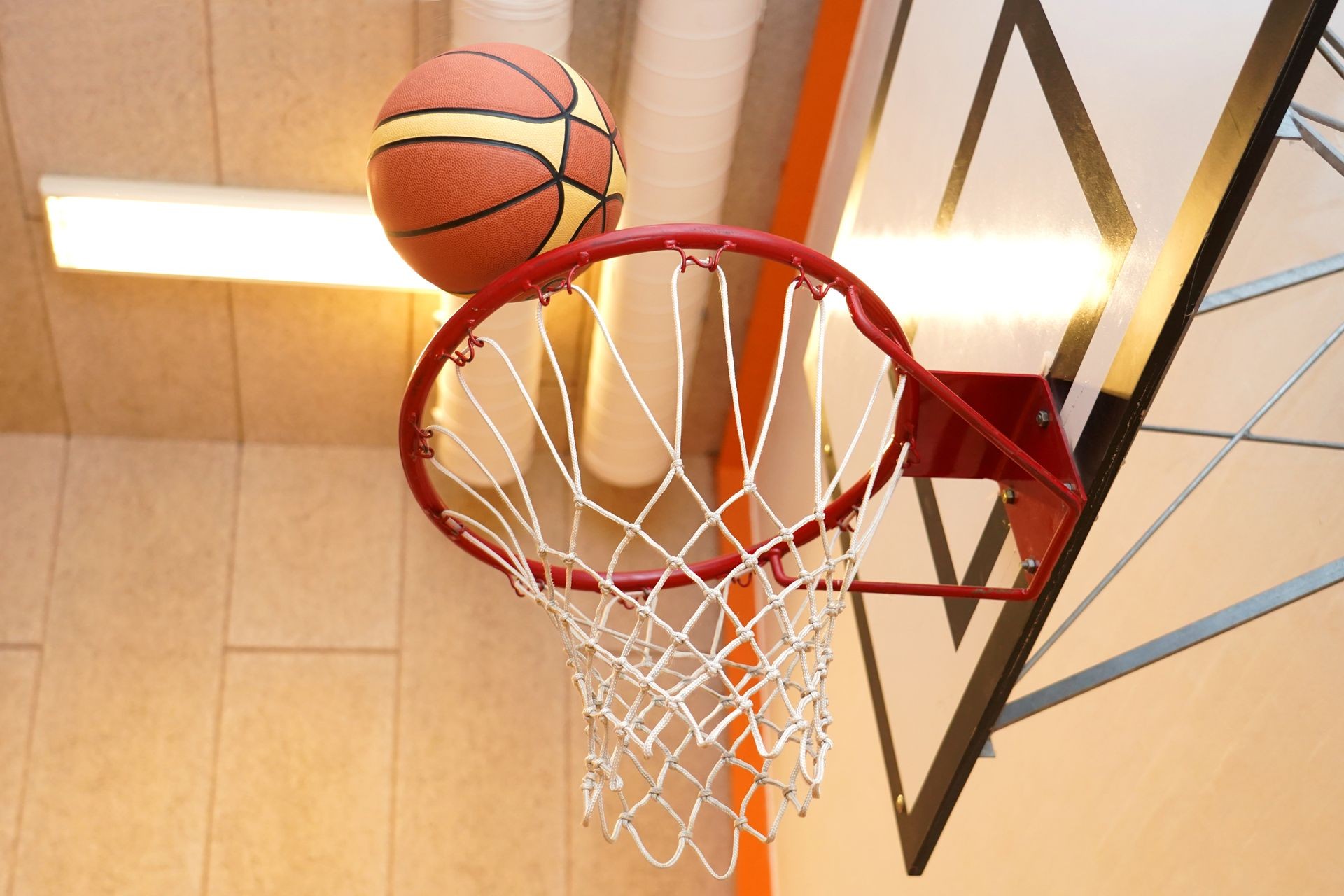 Basketball hoop and basket ball  in a sportshall.